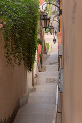 Steep stone stairway with lanterns and ivy-covered walls in Old Town, Warsaw, Poland