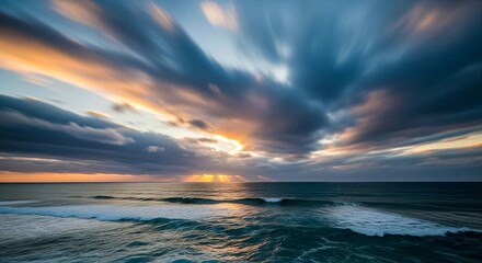 Obraz premium A long exposure shot of a serene ocean with a dynamic sunset sky.