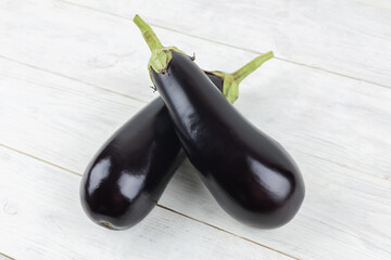 Two Fresh ripe black eggplants over wooden background for cooking