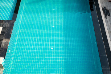 Clean turquoise swimming pool with ceramic tiles reflecting sunlight, symbolizing relaxation, leisure, summer vacation, wellness, and luxury lifestyle, perfect for travel, resort, and spa concepts.