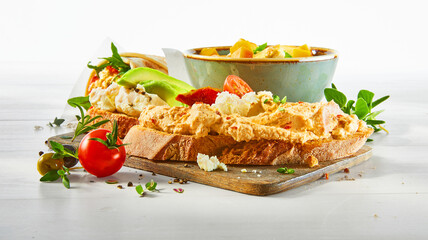 Eintopf mit Brot auf Holzbrett mit frischer Gemüse Quark Creme