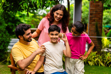 Parents and kids enjoying playful moment using string telephone in backyard garden