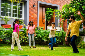 Indian family playing Langdi or one-leg hop game in garden, enjoying energetic outdoor fun
