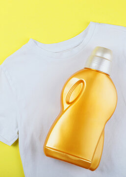 Laundry detergent bottles and clothes on the table. Household chemicals. Vertical photo format