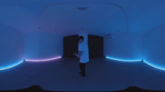 Man in a room with blue and pink lights. Suitable for nightlife themes or party promotions. Vibrant colors, high energy.