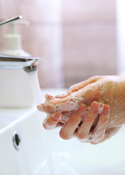 girl washes her hands with soap, hygiene and cleanliness of hands. Vertical photo format