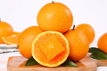 Fresh Orange Citrus Fruits on Wooden Cutting Board with Green Leaves