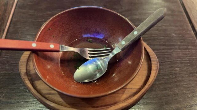 Dirty plate with food leftovers and fork on marble background, top view. Space for text