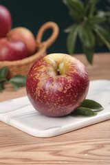 Fresh Red Apple on Cutting Board Kitchen Scene with Fruit Basket