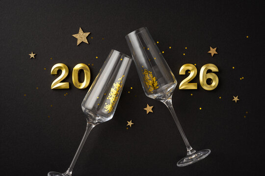 Gold adorned champagne glasses celebrating New Year's Eve for 2026, with festive decorations - Powered by Adobe