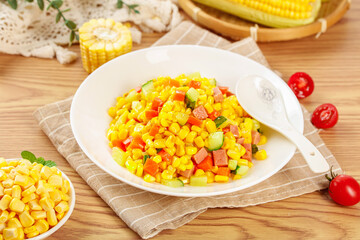 Fresh corn kernels salad with vegetables and tomatoes on wooden table - healthy summer dish