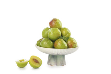 Fresh Green Plums in White Ceramic Bowl with Cut Halves Isolated on White Background