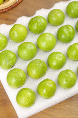 Fresh Green Plums with Water Drops on White Towel - Healthy Organic Fruit Display