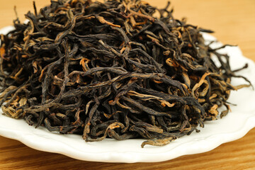 Dried Black Tea Leaves on White Plate - Organic Loose Leaf Tea Close-Up with Shallow Depth of Field