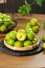 Fresh Green Plums in Bamboo Basket on Slate Board - Healthy Organic Fruit Kitchen Display