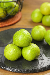Fresh Green Plums with Water Droplets on Slate Board - Crisp Sichuan Fruit Display