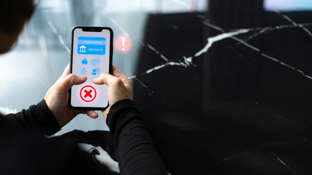 A person holding a smartphone with a mobile banking app showing an error and warning icon. Concept for online banking security, financial fraud alert, cyber risk, and digital payment problem.