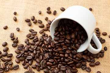 コーヒーカップとこぼれたコーヒー豆
