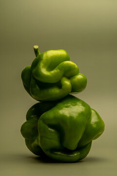 Naklejki Artistic abstract still life of green bell peppers with surreal organic shapes, sculptural vegetable stack, creative minimal food photography, concept, healthy eating, balancing structure
