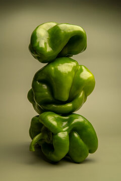 Naklejki Artistic abstract still life of green bell peppers with surreal organic shapes, sculptural vegetable stack, creative minimal food photography, concept, healthy eating, balancing structure