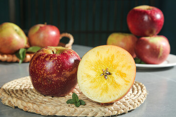 Fresh Red Apples with Yellow Flesh Cross-Section on Wicker Placemat Kitchen Still Life