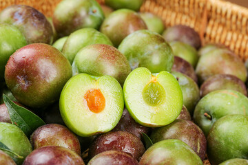 Fresh Sichuan Plums in Basket - Green and Red Asian Stone Fruit with Orange Pits