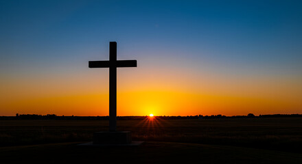 Silhouette of the Cross at Dawn: A stark silhouette of a cross stands against a vibrant sunrise, evoking a sense of reverence and hope, a symbol of faith and spiritual awakening. 