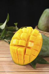 Fresh Cut Mango Cubes from Panzhihua Sichuan China on Wooden Background with Green Leaves