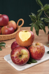 Fresh Red Apples with Heart Shape Carving on Rustic Wooden Table Display