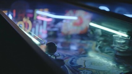 Pinball machine with lights and steel ball. Perfect for gaming websites, entertainment blogs, or retrothemed designs needing a vibrant touch.