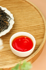 Chinese Tea Ceremony with Freshly Brewed Red Tea and Loose Leaves on Bamboo Tray