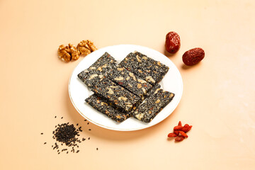 Homemade sesame walnut energy bars with dates - healthy nourishing snack cake on white plate