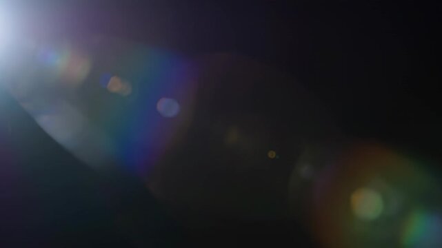 A seamlessly looping video showcasing a gentle soft lens flare with subtle prismatic colors shifting and blending harmoniously subtle light, motion, gentle soft lens flare