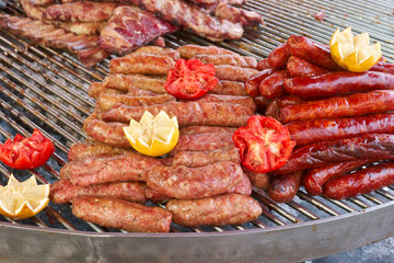 Sizzling sausages and meats on a grill during a summer barbecue gathering in the countryside