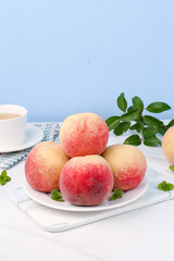 Fresh Red Golden Peaches on White Plate with Green Leaves Kitchen Still Life