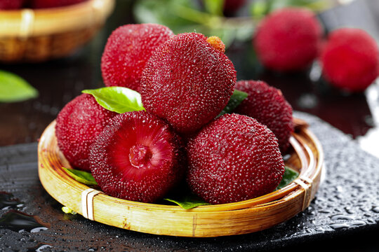Fresh Red Bayberries in Bamboo Basket on Dark Slate - Healthy Asian Fruit Display