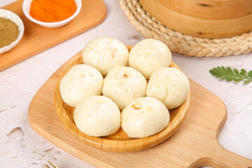 Traditional Chinese Xiaolongbao Soup Dumplings on Bamboo Serving Plate with Spices