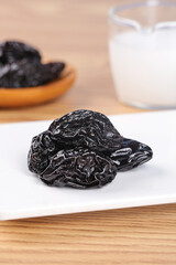 Dried Xinjiang Prunes Air-Dried Fruit Healthy Snack on White Plate Close-up Food Photography
