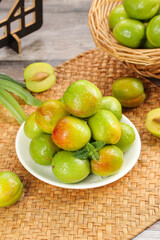 Fresh Green Apricots from Xinjiang Aksu Region in Bowl on Bamboo Mat - Organic Fruit Display
