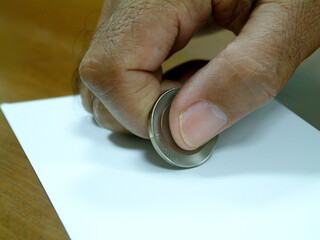 Close-up of a man's hand rubbing paper with a coin to get a surprise.