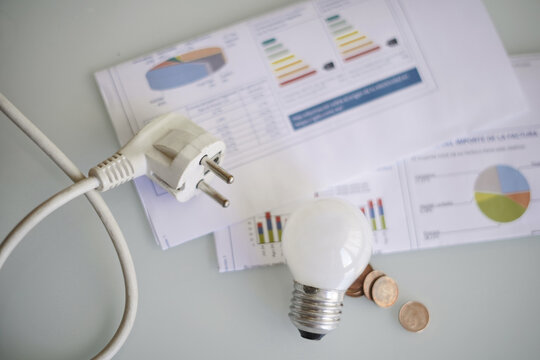 Electricity bill with a plug and light bulb, household economics and energy or electricity prices