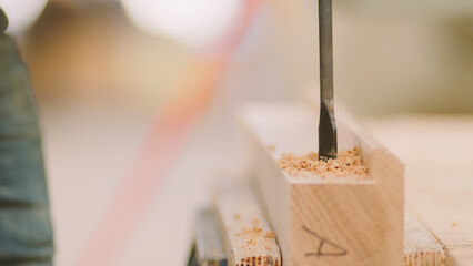 Close Up Of Carpenter At Workbench In Workshop Using Cordless Electric Drill