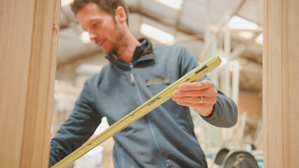 Close Up Of Male Carpenter Working In Woodwork Workshop Making And Measuring Window Frame