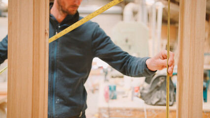 Close Up Of Male Carpenter Working In Woodwork Workshop Making And Measuring Window Frame