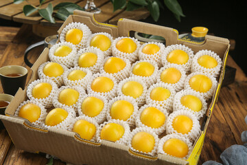 Fresh Apricots in Protective Packaging Box Ready for Delivery on Rustic Wooden Table