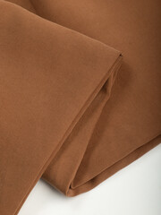 Dark dense fabric for sewing clothes, ironed, the texture of the fabric is visible
