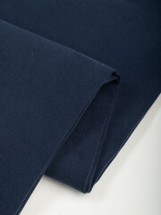 Dark dense fabric for sewing clothes, ironed, the texture of the fabric is visible