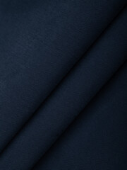 Dark dense fabric for sewing clothes, ironed, the texture of the fabric is visible