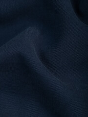 Dark dense fabric for sewing clothes, ironed, the texture of the fabric is visible