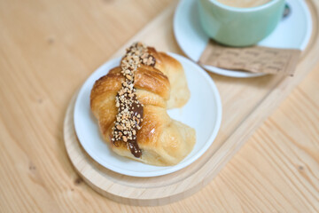 Delicious croissant with chocolate and nuts served with cappuccino